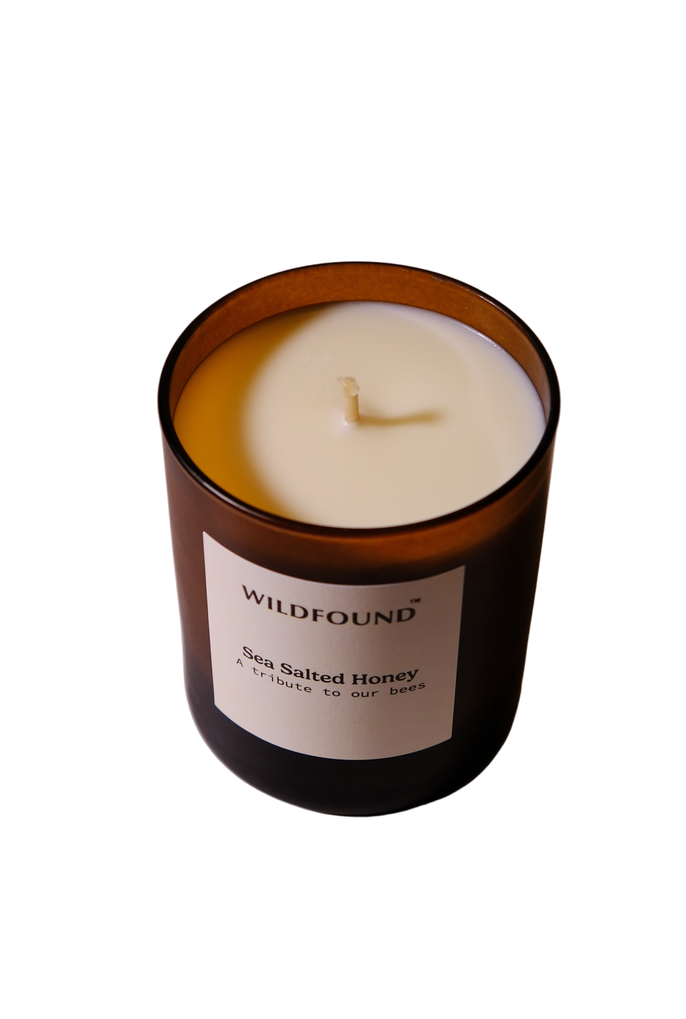 Candle in a glass jar with a label on a white surface